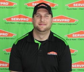 image of male sitting in front of SERVPRO backdrop