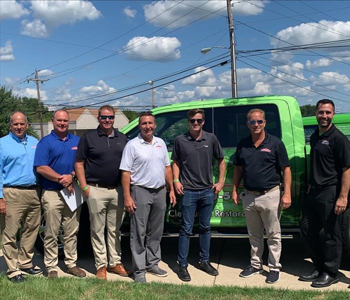 image of SERVPRO employees/owners in front of a SERVPRO truck smiling for a picture