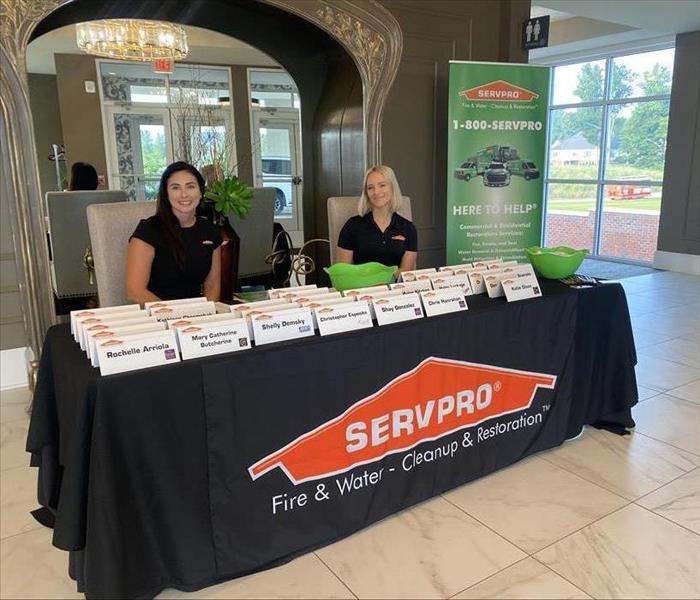 SERVPRO team members sit by the registration table. 