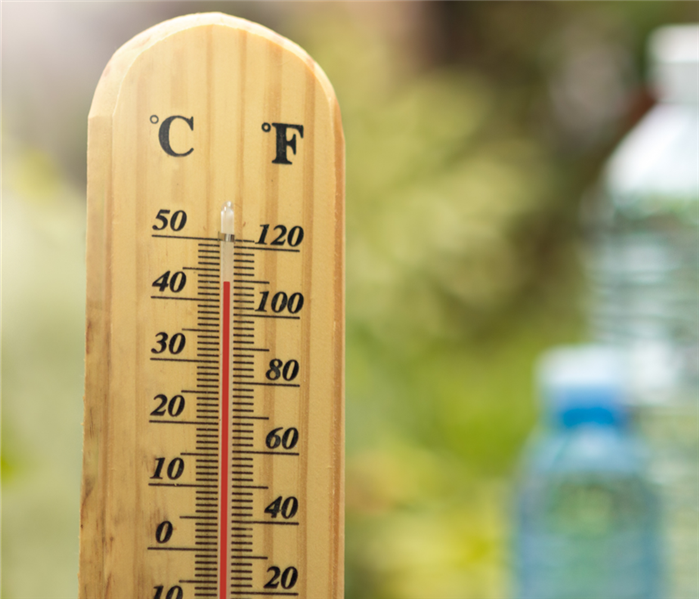 A wooden thermometer displays a temperature of  110 degrees Fahrenheit