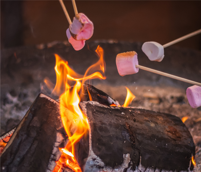 S'mores are being roasted over a campfire.